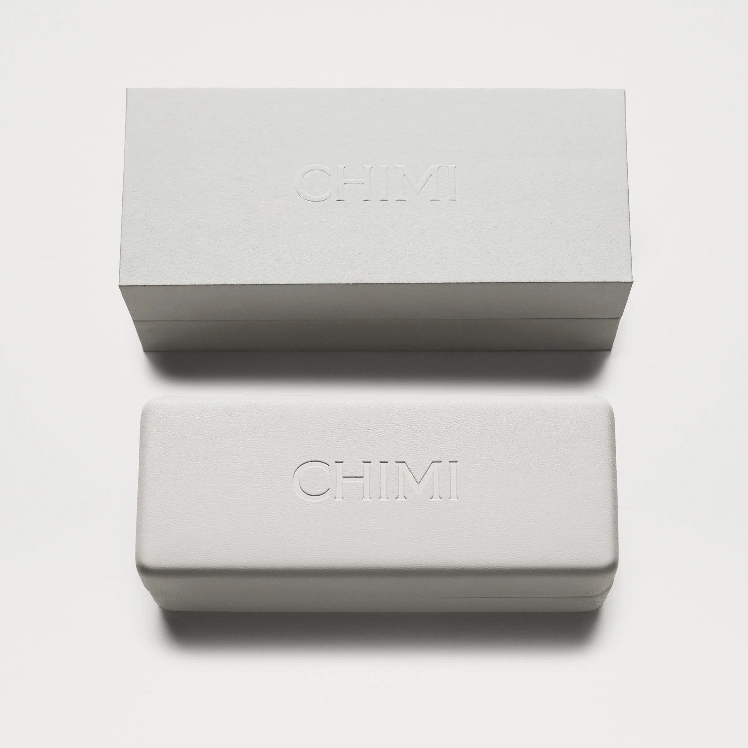 Two rectangular Chimi sunglasses brand boxes in a minimalist style stacked on a white background.