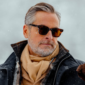 A man wearing Chimi Model 04 Tortoise Brown Lenses Sunglasses 45mm and a scarf in the snow.