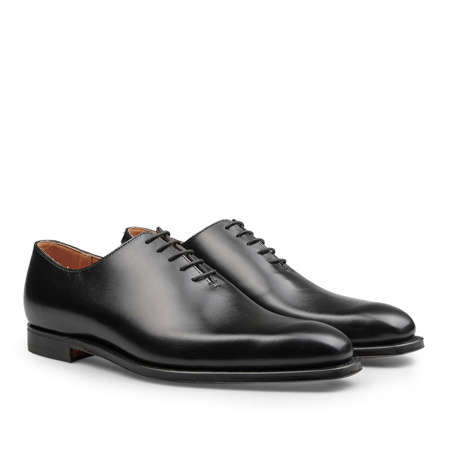 Featuring a pair of exquisitely crafted Alex Wholecuts by Crockett & Jones, these polished black calf leather lace-up dress shoes boast a refined silhouette with a low heel when viewed from the side.