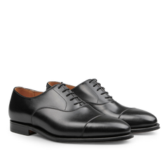 The Black Calf Leather Connaught Cap Oxfords by Crockett & Jones are crafted in fine calf leather, showcasing a Goodyear-welted construction with a lace-up closure and a sleek finish.