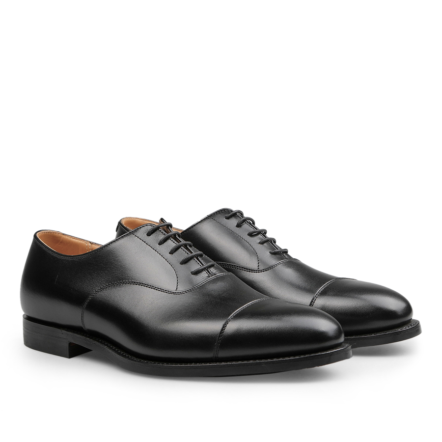 A pair of Black Calf Leather Connaught II Cap Oxfords by Crockett & Jones, featuring an elegant design with laces and a Goodyear-welted straight cap oxford style.