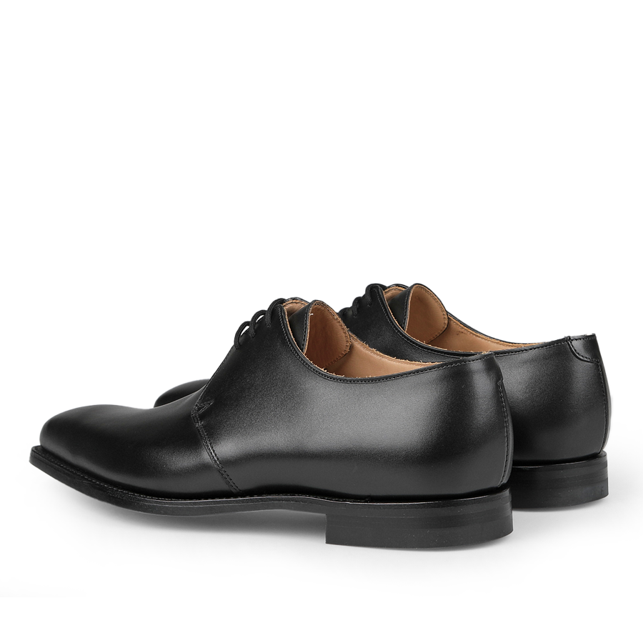 Crockett & Jones Black Calf Leather Highbury Derbies, featuring a classic plain-toe derby design with laces, are shown in a three-quarter rear view.