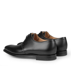 Crockett & Jones Black Calf Leather Highbury Derbies, featuring a classic plain-toe derby design with laces, are shown in a three-quarter rear view.