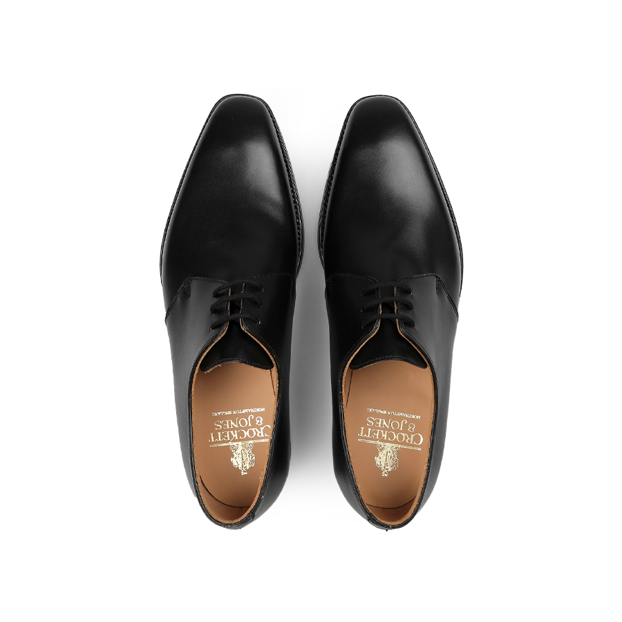 Pair of black leather derbies shot from above, crafted by Crockett & Jones in sleek black calf leather with a nod to the timeless Highbury style.