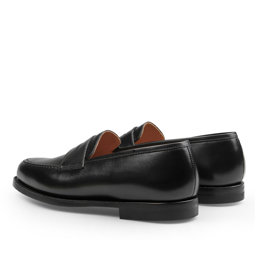 A pair of Crockett & Jones Black Fine Calf Leather Boston Loafers, featuring visible stitching and a low heel, are displayed from the back angle.