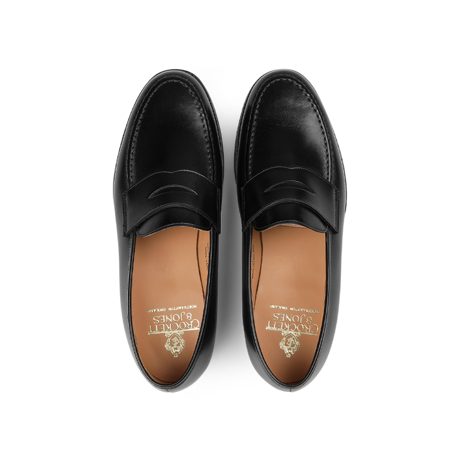 An overhead view of Boston Loafers from Crockett & Jones, expertly crafted from fine black calf leather and featuring brown insoles.