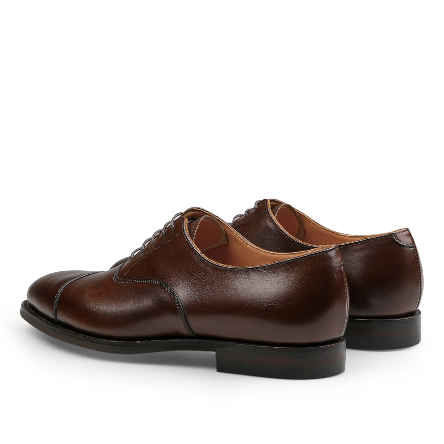 A rear and side view of the Dark Brown Burnished Calf Connaught Cap Oxfords by Crockett & Jones.