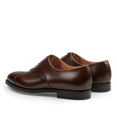 A rear and side view of the Dark Brown Burnished Calf Connaught Cap Oxfords by Crockett & Jones.