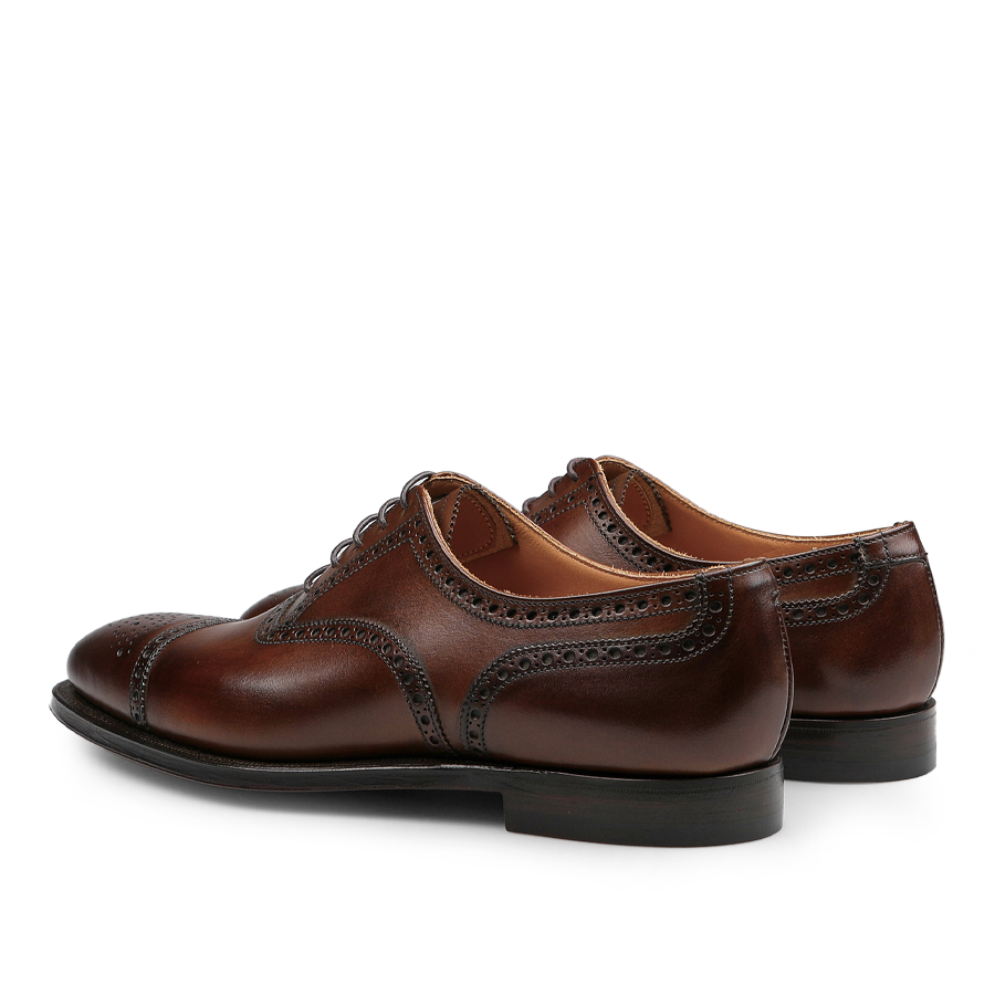 Introducing the Dark Brown Calf Leather Westfield Semi-Brogues by Crockett & Jones, these polished Oxford shoes showcase elegant semi-brogue detailing and durable black soles, making them an ideal choice for adding a touch of refinement to any ensemble.