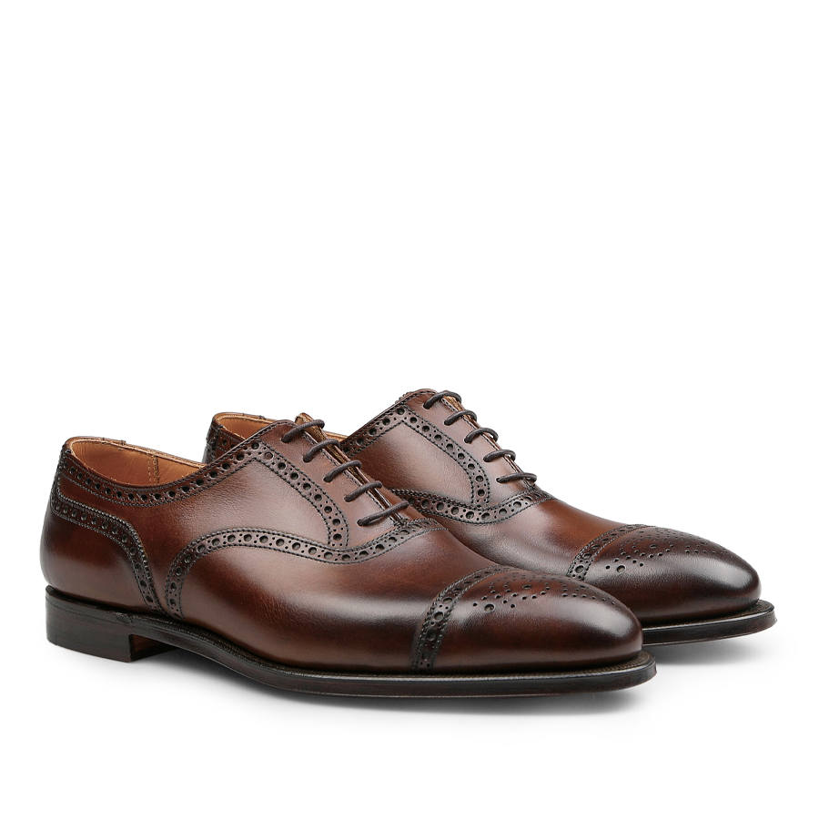 A pair of Dark Brown Calf Leather Westfield Semi-Brogues from Crockett & Jones, showcasing semi-brogue decorative perforations and black soles.