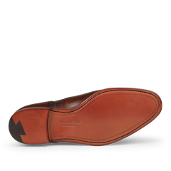 The image showcases the sole of a dark brown calf leather dress shoe with semi-brogue detailing, featuring visible stitching and a black arrow design. The shoe proudly displays the brand "Crockett & Jones" along with the "LOCK SLIP" imprint, capturing Westfield's refined craftsmanship in their Dark Brown Calf Leather Westfield Semi-Brogues.