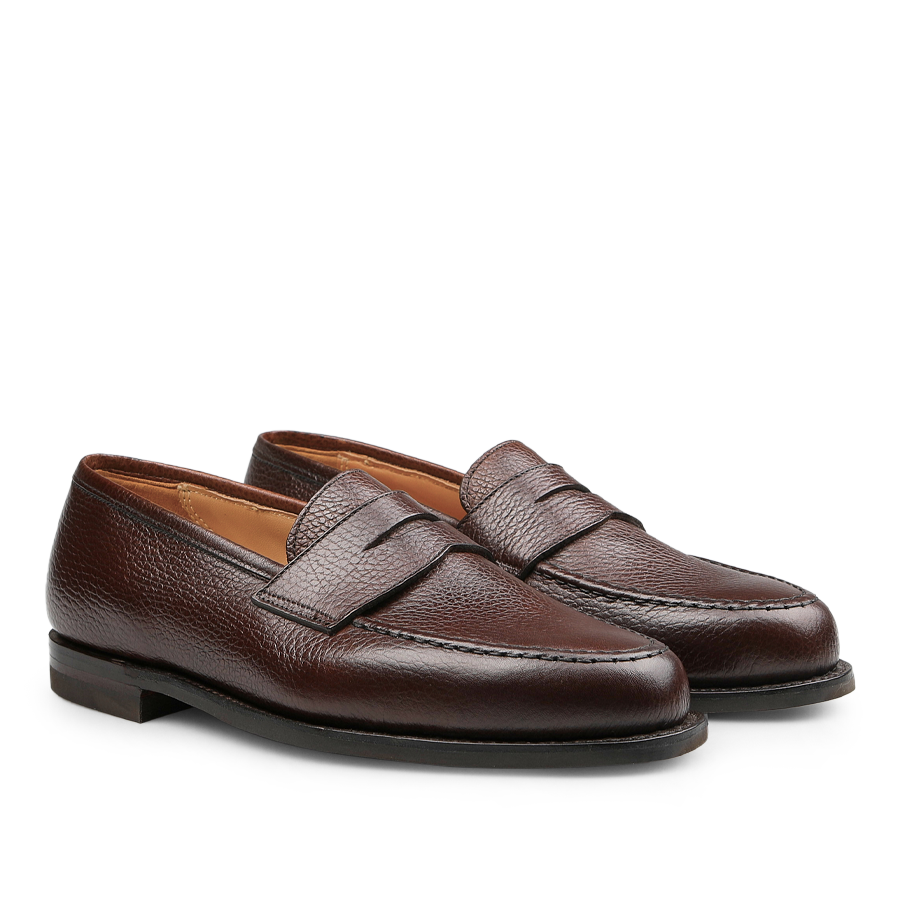 Crockett & Jones presents the Dark Brown Country Calf Leather Boston Loafers, featuring a textured finish and city rubber sole, displayed side by side on a white background. These loafers epitomize the enduring elegance of the classic Boston penny loafer style.