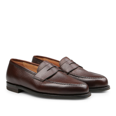 Crockett & Jones presents the Dark Brown Country Calf Leather Boston Loafers, featuring a textured finish and city rubber sole, displayed side by side on a white background. These loafers epitomize the enduring elegance of the classic Boston penny loafer style.