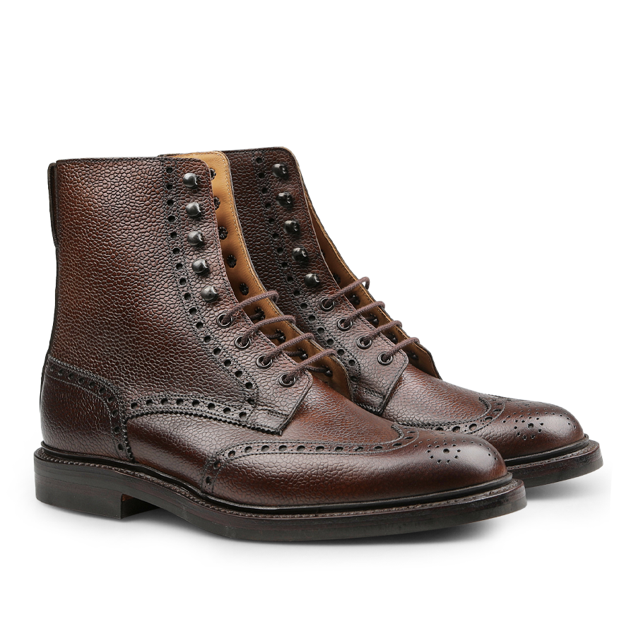 The Dark Brown Scotch Grain Leather Islay Boots by Crockett & Jones showcase intricate perforated detailing on scotch grain calf leather with dark soles, all presented against a clean white background.