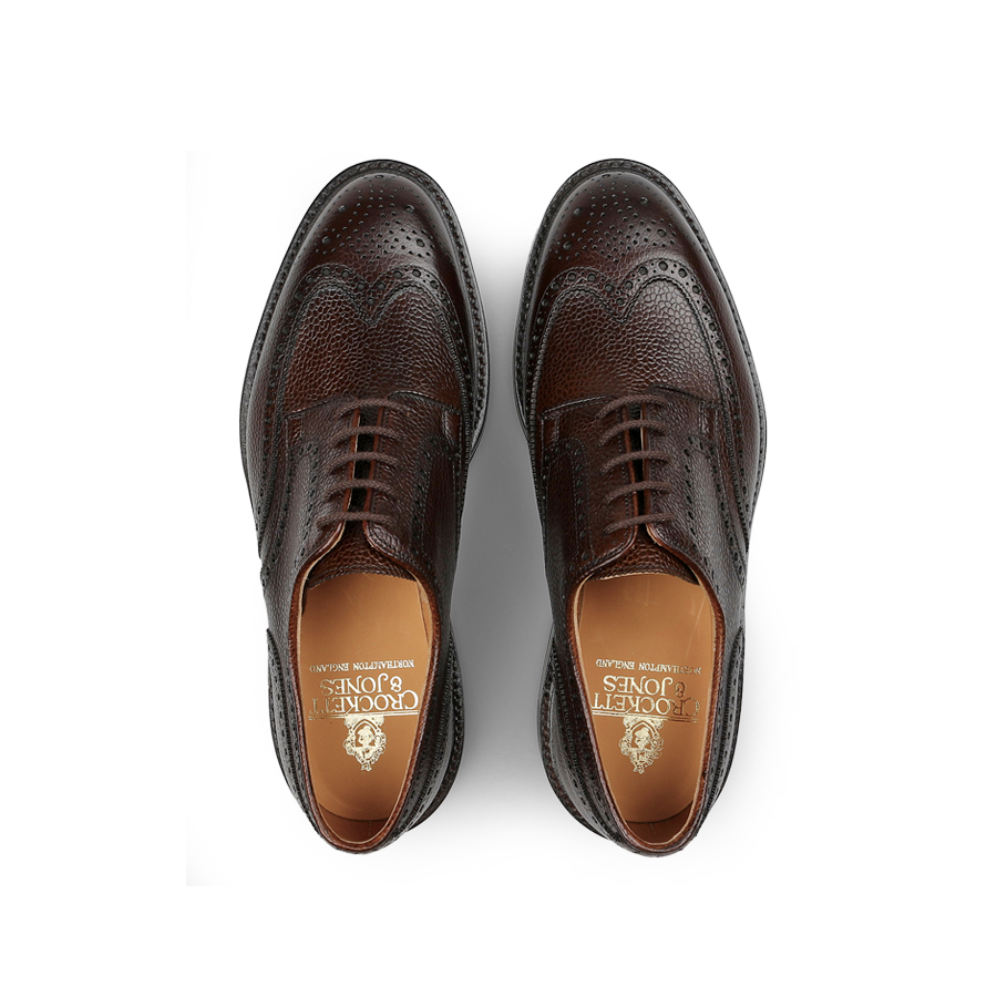 The Dark Brown Scotch Grain Leather Pembroke Brogues by Crockett & Jones, viewed from above, feature decorative perforations and embossed branding on the insole.