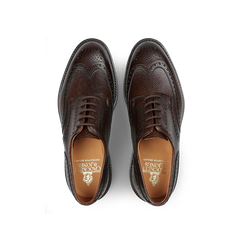 The Dark Brown Scotch Grain Leather Pembroke Brogues by Crockett & Jones, viewed from above, feature decorative perforations and embossed branding on the insole.