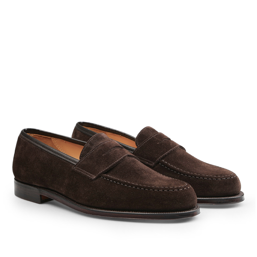 Dark brown suede leather Boston loafers with a raised seam, low heel, and classic penny loafer design by Crockett & Jones.