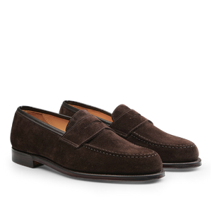 Dark brown suede leather Boston loafers with a raised seam, low heel, and classic penny loafer design by Crockett & Jones.