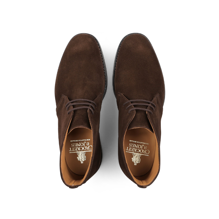 A pair of Dark Brown Suede Leather Chiltern Boots from Crockett & Jones, viewed from above, highlights branded insoles and chukka boot elegance.