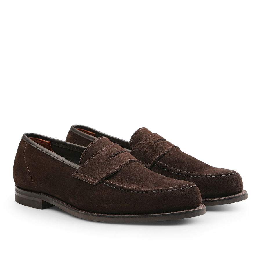 Positioned side by side on a plain background is a pair of Crockett & Jones Dark Brown Suede Leather Harvard II Loafers, showcasing their stitching details and low heels.