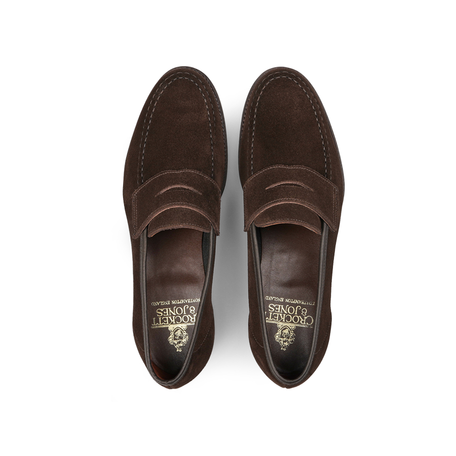 The Crockett & Jones Dark Brown Suede Leather Harvard II Loafers, featuring stitching and a visible insole logo, exemplify the classic style when viewed from above.