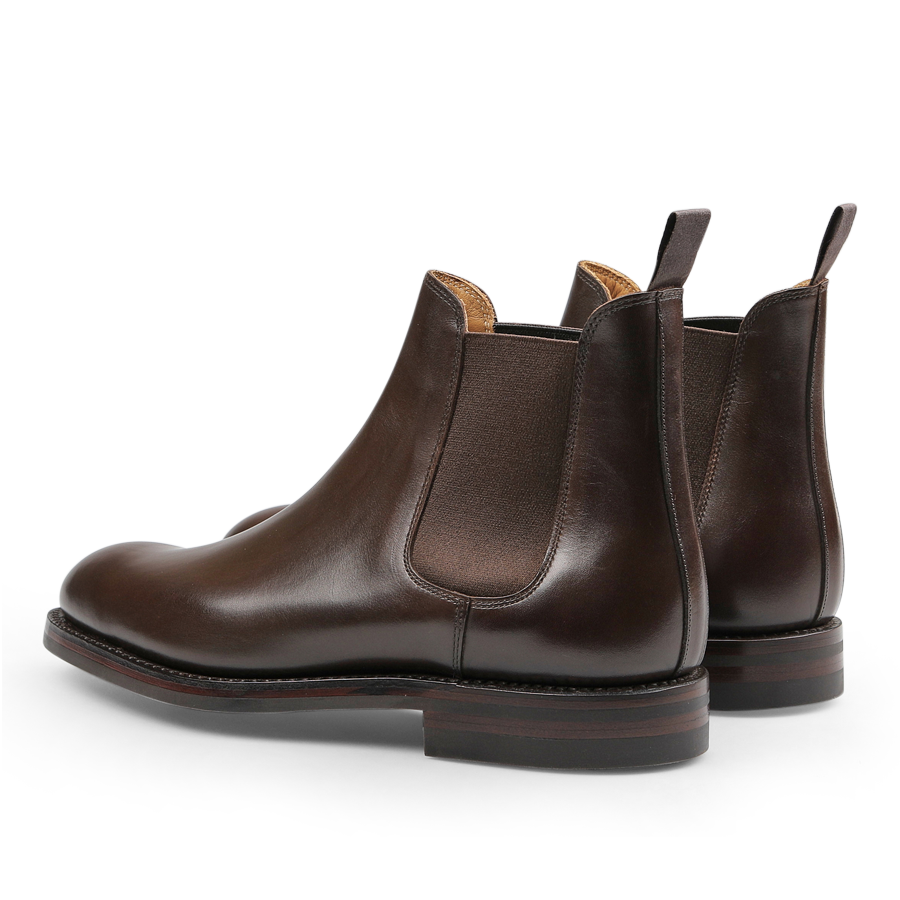 The Dark Brown Wax Calf Leather Chelsea V Boots by Crockett & Jones showcase elastic side panels and pull tabs, as seen from the back.