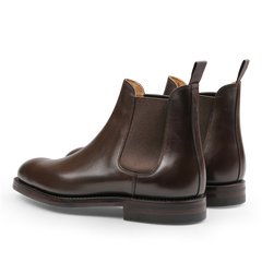 The Dark Brown Wax Calf Leather Chelsea V Boots by Crockett & Jones showcase elastic side panels and pull tabs, as seen from the back.