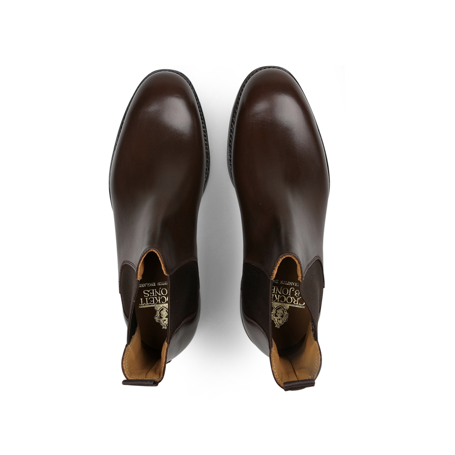 A pair of Dark Brown Wax Calf Leather Chelsea V Boots by Crockett & Jones, crafted from polished leather and viewed from above.