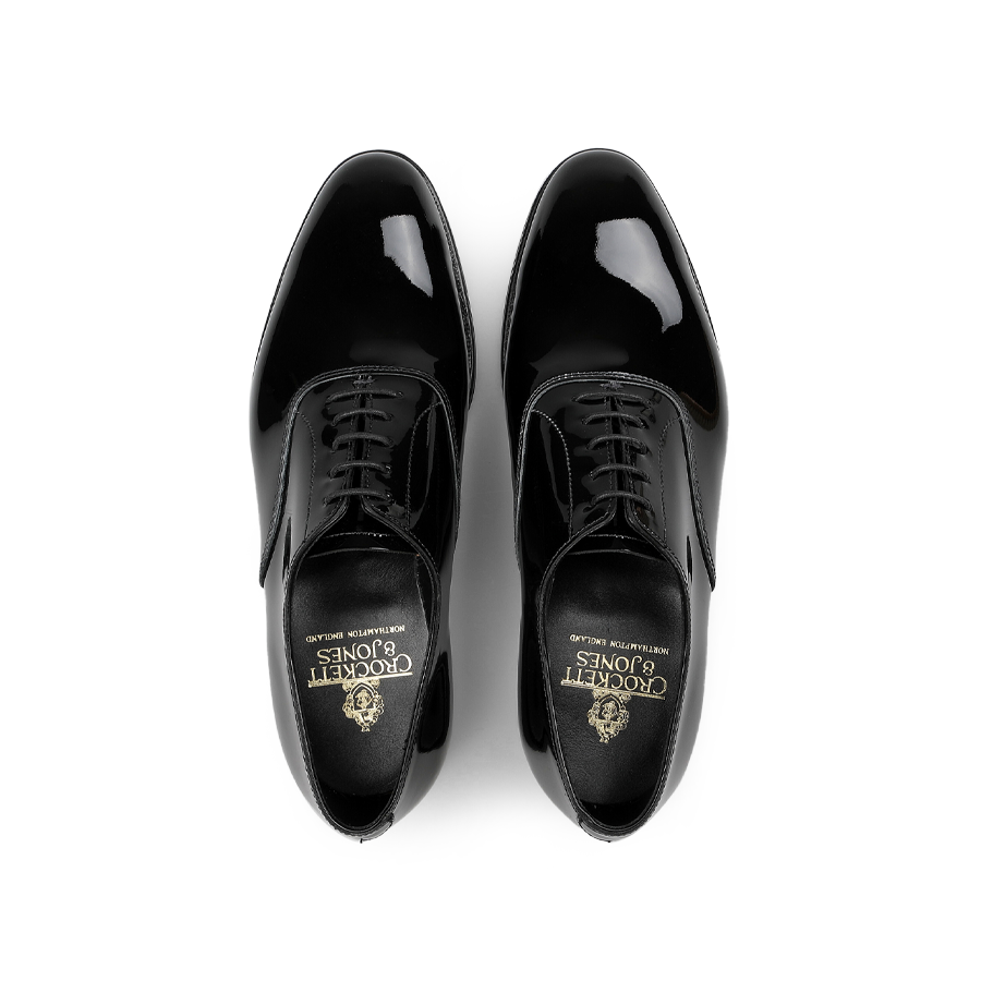 The Black Patent Calf Leather Overton Oxfords by Crockett & Jones are crafted from shiny black patent calf leather and feature a classic design with laces, viewed from above.