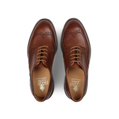 A pair of Tan Scotch Grain Leather Pembroke Brogues from Crockett & Jones, crafted with laces and featuring decorative perforations, a visible shoe label, and classic Goodyear-welted construction.