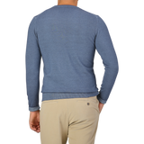 A person wearing a light blue long-sleeve shirt and beige pants, photographed from the back against a plain backdrop, their ensemble complemented by Daniele Fiesoli's Dark Blue Melange Merino Wool Crewneck.