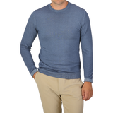 A person wearing a Daniele Fiesoli Dark Blue Melange Merino Wool Crewneck and beige pants stands with one hand in their pocket against a plain background.