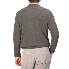 A person wearing a Corteccia Brown Cashmere V-Neck Sweater by Daniele Fiesoli and light-colored pants, photographed from the back against a neutral background.