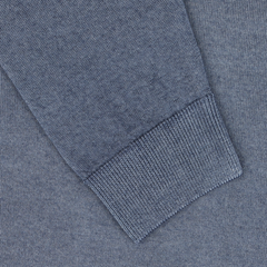 Close-up of a Daniele Fiesoli Dark Blue Melange Merino Wool Crewneck sweater sleeve with a ribbed cuff, lying on a matching textured blue textile background. Made from extra fine merino wool, the sleeve appears to be part of a high-quality garment made in Italy.