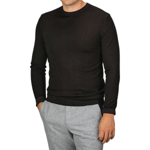 A person wearing a Daniele Fiesoli Dark Brown Merino Wool Crewneck with light gray pants. The individual has one hand in their pocket and is not showing their face.