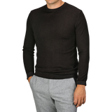 A person wearing a Daniele Fiesoli Dark Brown Merino Wool Crewneck with light gray pants. The individual has one hand in their pocket and is not showing their face.