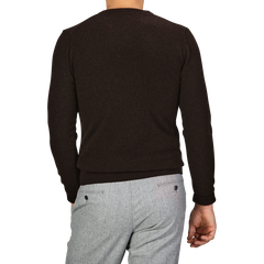 A person wearing a Daniele Fiesoli Dark Brown Wool Cashmere Crewneck and light gray pants is standing with their back turned to the camera.