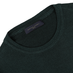 A Dark Green Merino Wool Crewneck by Daniele Fiesoli, made from extra fine merino wool, featuring a label reading "DANIELE FIESOLI, ITALY" at the collar.