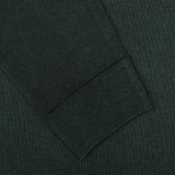 Close-up of a dark green knitted sleeve cuff on a matching fabric background, part of the exquisite Daniele Fiesoli Dark Green Wool Cashmere Crewneck sweater.