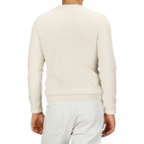 Individual wearing a Daniele Fiesoli Ecru Wool Cashmere Crewneck sweater made in Italy and white pants, captured from behind.