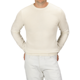 A person wearing a Daniele Fiesoli Ecru Wool Cashmere Crewneck and white pants, standing with hands in pockets, showing their torso and upper legs.