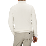 A person wearing an Ecru Wool Cashmere Quarter Zip Sweater by Daniele Fiesoli and beige pants is seen from behind.