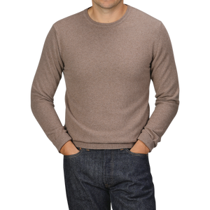 A person wearing a Light Brown Wool Cashmere Crewneck from Daniele Fiesoli and dark jeans with their hands in their pockets, standing against a plain background. The head is cropped out of the image.