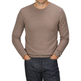 A person wearing a Light Brown Wool Cashmere Crewneck from Daniele Fiesoli and dark jeans with their hands in their pockets, standing against a plain background. The head is cropped out of the image.