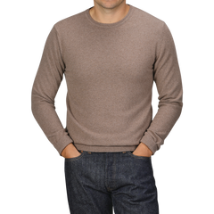 A person wearing a Light Brown Wool Cashmere Crewneck from Daniele Fiesoli and dark jeans with their hands in their pockets, standing against a plain background. The head is cropped out of the image.