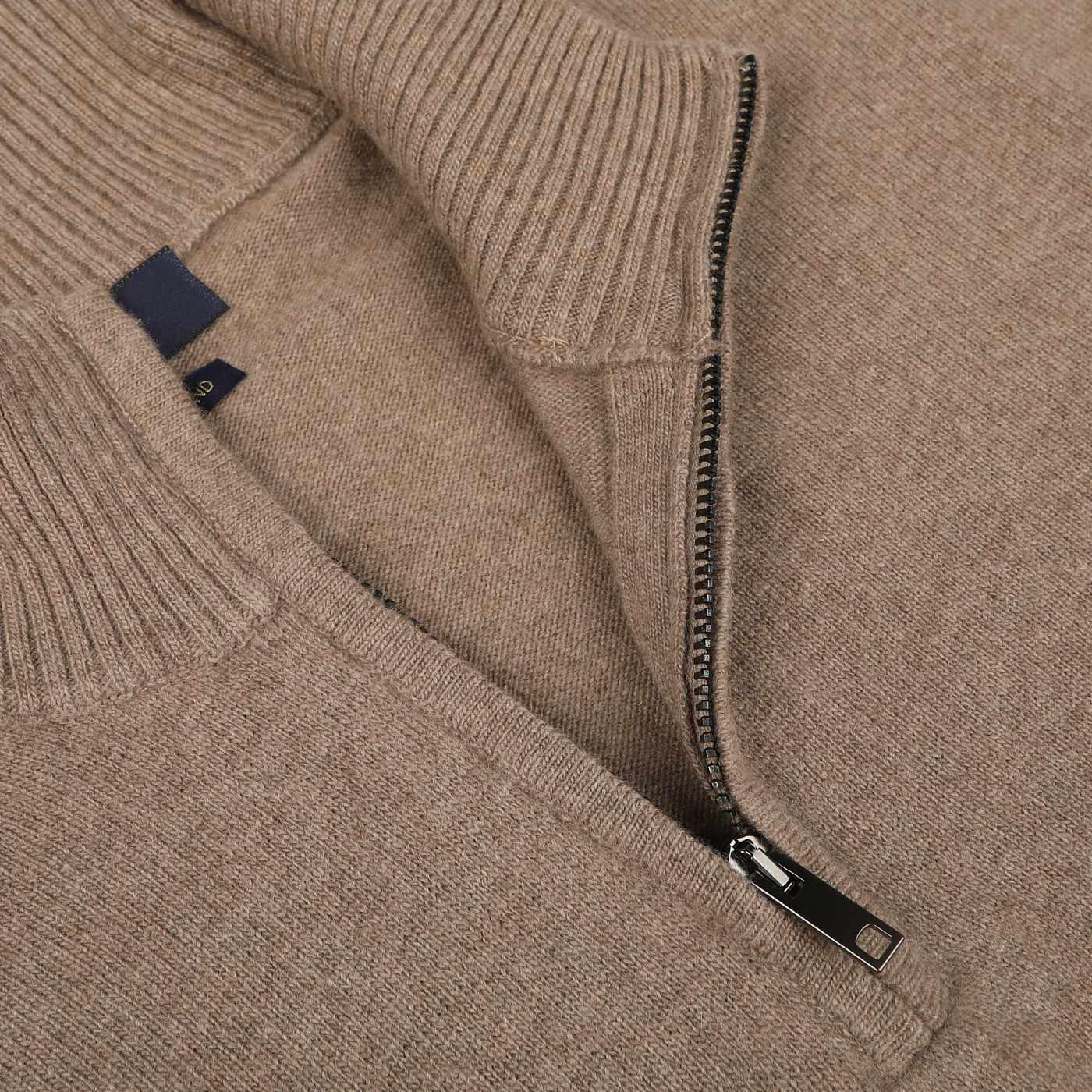 A close-up of a Daniele Fiesoli Light Brown Wool Cashmere Quarter Zip Sweater with a half-zip collar, featuring a visible zipper partially opened. The garment has a ribbed texture at the collar and an “Absolutely made in Italy” fabric tag inside.