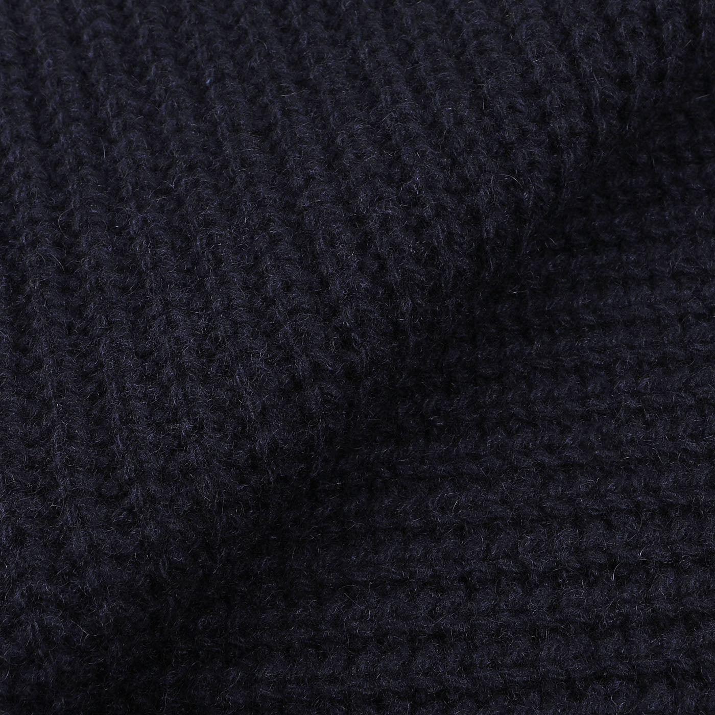 Close-up image of dark navy blue, cable knit fabric from an upcycled Daniele Fiesoli Navy Blue Cable Knit Cashmere Scarf.