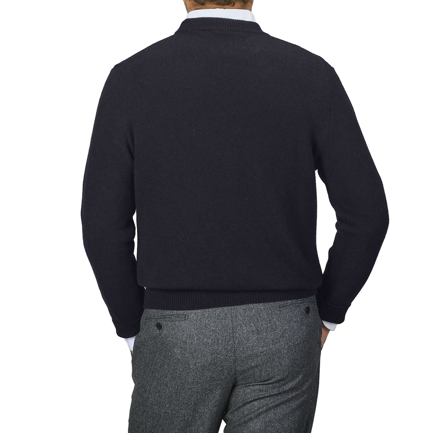 A person wearing a navy blue cashmere crewneck sweater by Daniele Fiesoli and gray pants is seen from the back against a gray background.