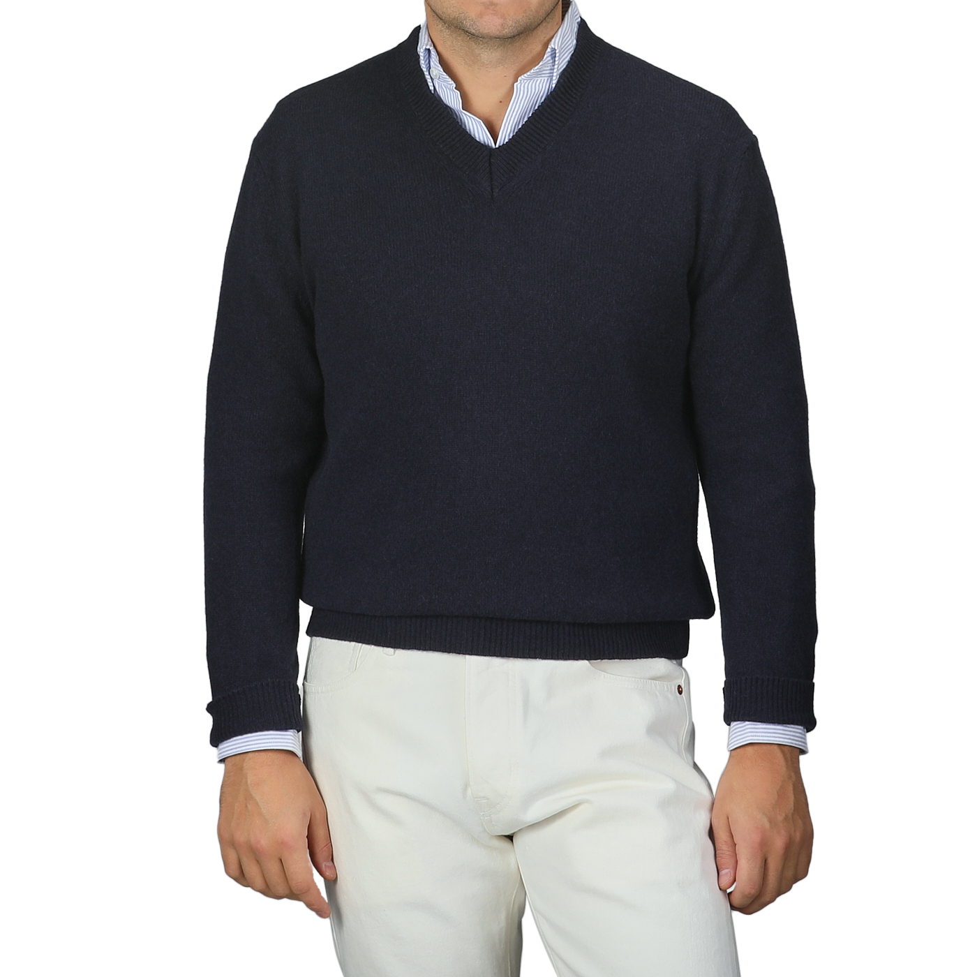 A person is stylishly dressed in a Daniele Fiesoli Navy Blue Cashmere V-Neck Sweater, crafted from upcycled cashmere, over a light blue collared shirt paired with crisp white pants.