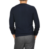 Back view of a person wearing the Navy Blue Melange Merino Wool Crewneck by Daniele Fiesoli and gray pants, standing with hands in pockets.